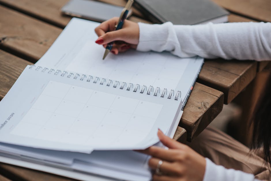 Image of a person holding a study schedule, showing different time slots for studying, breaks, and reminders